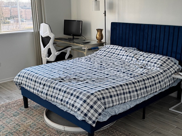 bedroom featuring baseboards and wood tiled floor