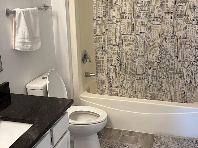 bathroom featuring vanity, toilet, shower / bath combo, and wood finish floors