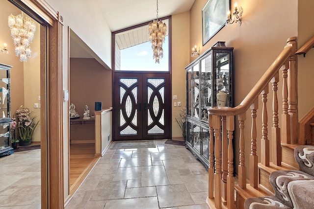 entryway with a high ceiling, a healthy amount of sunlight, a notable chandelier, and stairs