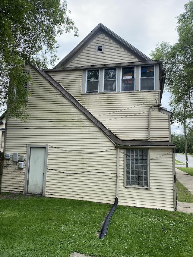 back of house featuring a lawn