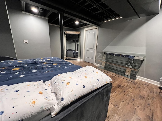 bedroom featuring a closet, baseboards, and wood finished floors