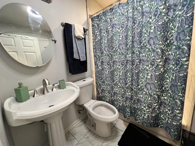 bathroom featuring curtained shower, toilet, and marble finish floor