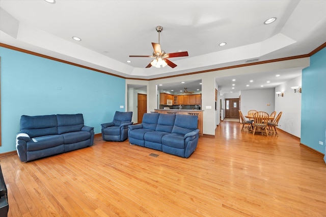 living area featuring visible vents, a tray ceiling, recessed lighting, light wood-style floors, and ceiling fan