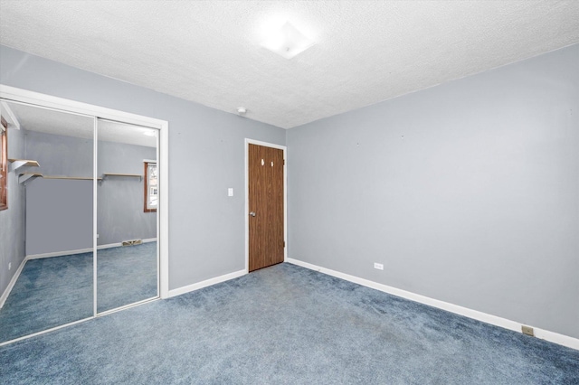 unfurnished bedroom featuring a closet, baseboards, a textured ceiling, and carpet