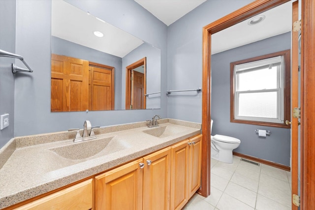 bathroom featuring a sink, visible vents, toilet, and double vanity