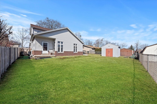 back of house featuring brick siding, a shed, a yard, an outdoor structure, and a fenced backyard