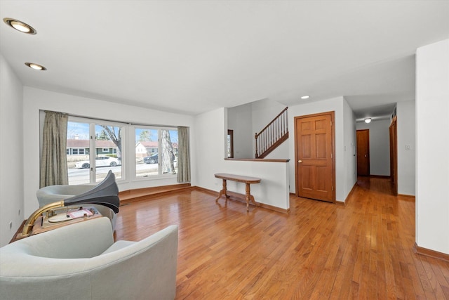 living area with recessed lighting, stairway, baseboards, and light wood-style flooring