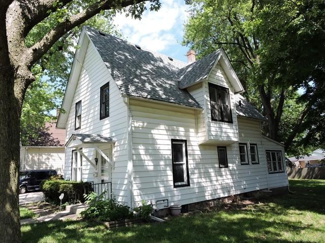 833 Pleasant St, Dekalb, IL 60115 - view of property exterior with a shingled roof, a lawn, and a chimney
