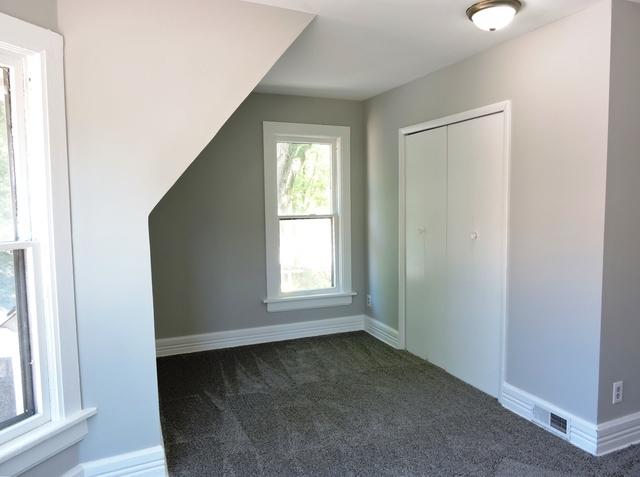 833 Pleasant St, Dekalb, IL 60115 - additional living space with dark colored carpet and baseboards