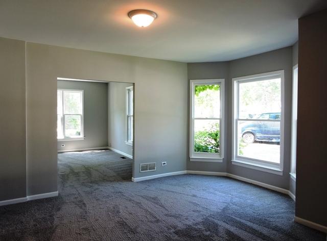 833 Pleasant St, Dekalb, IL 60115 - empty room with dark colored carpet and baseboards