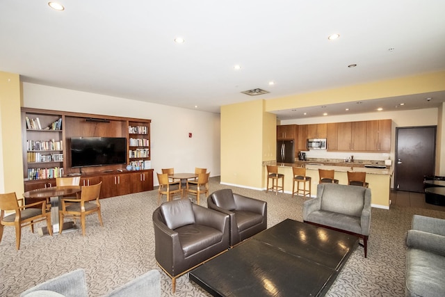 living area featuring baseboards, recessed lighting, visible vents, and light carpet