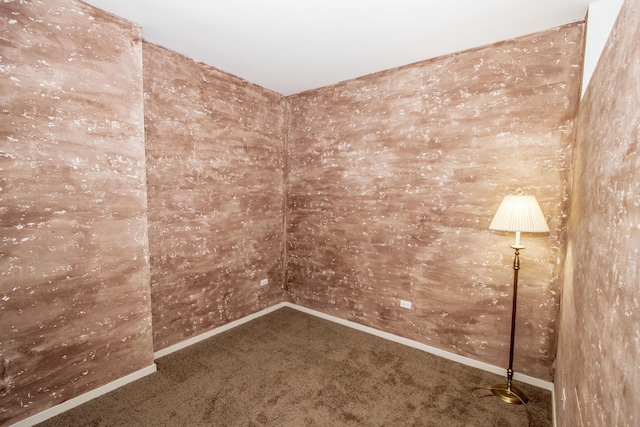 carpeted spare room featuring baseboards