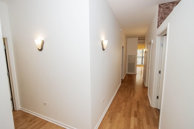 hallway with baseboards and light wood-style flooring