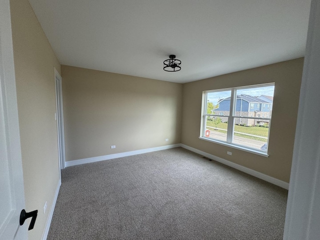 empty room featuring baseboards and carpet floors