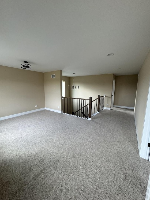 carpeted spare room featuring visible vents and baseboards
