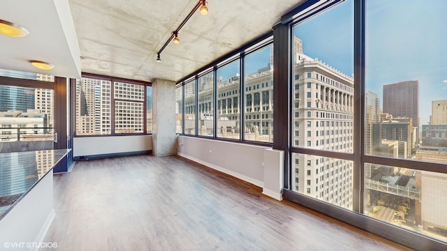 unfurnished sunroom featuring a city view and track lighting