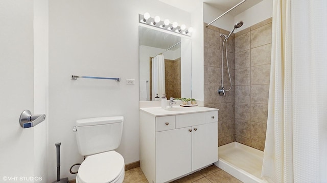 bathroom featuring baseboards, toilet, tiled shower, tile patterned floors, and vanity