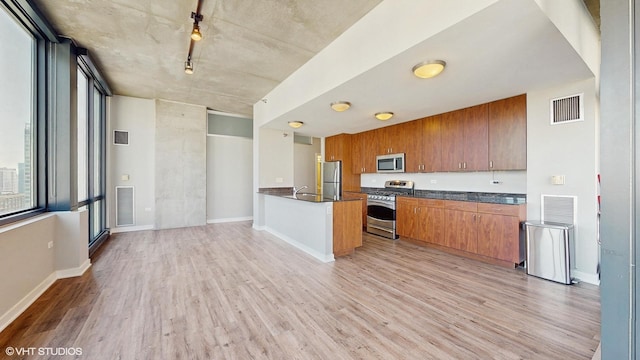 kitchen with light wood-style floors, visible vents, dark countertops, and appliances with stainless steel finishes