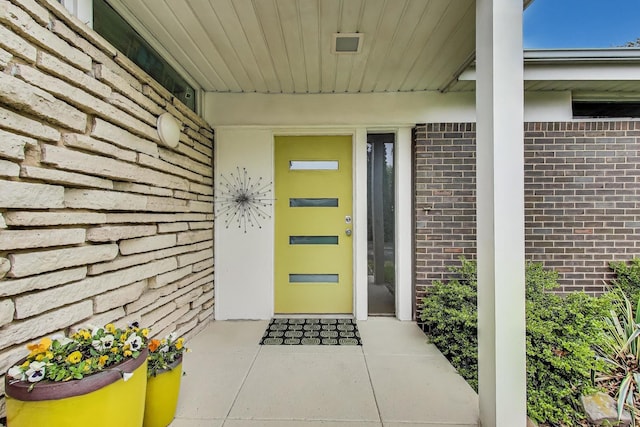 doorway to property with brick siding