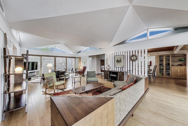 living area with wood finished floors and lofted ceiling