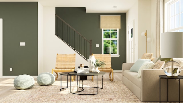 living area with baseboards, a healthy amount of sunlight, a towering ceiling, and stairs