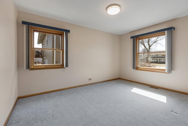 unfurnished room featuring visible vents, baseboards, and carpet floors