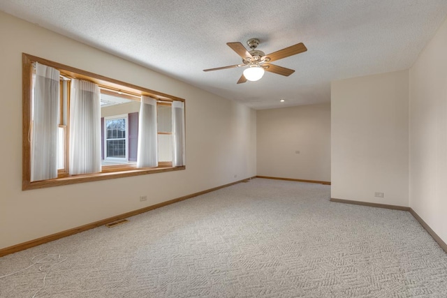 unfurnished room featuring baseboards, visible vents, ceiling fan, a textured ceiling, and light colored carpet