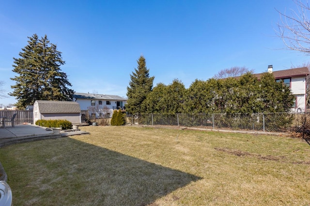 view of yard with a storage unit, an outdoor structure, and a fenced backyard