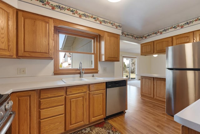 kitchen featuring brown cabinetry, stainless steel appliances, and a sink