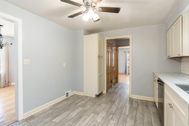 kitchen featuring visible vents, dishwasher, light stone counters, light wood-style floors, and a ceiling fan