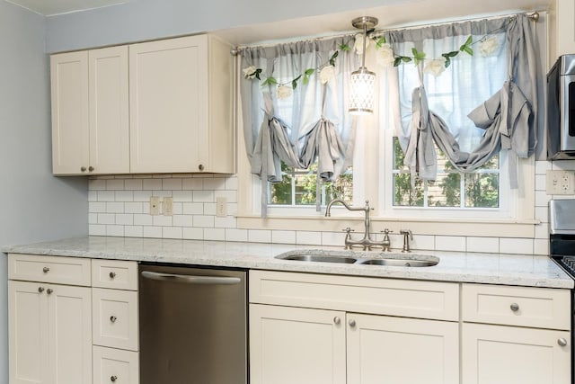 kitchen with a sink, light stone counters, backsplash, and dishwasher