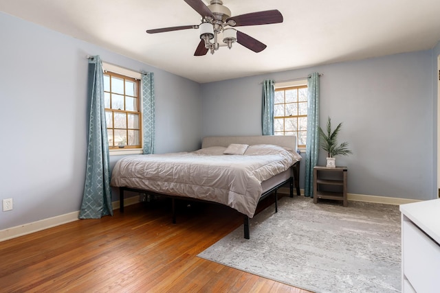 bedroom featuring ceiling fan, baseboards, and light wood-style flooring