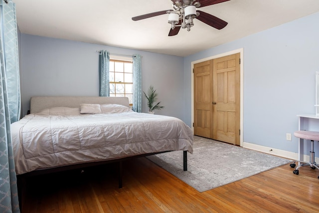 bedroom with ceiling fan, baseboards, and wood finished floors