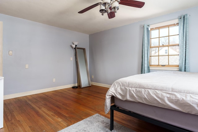 bedroom with ceiling fan, baseboards, and wood finished floors