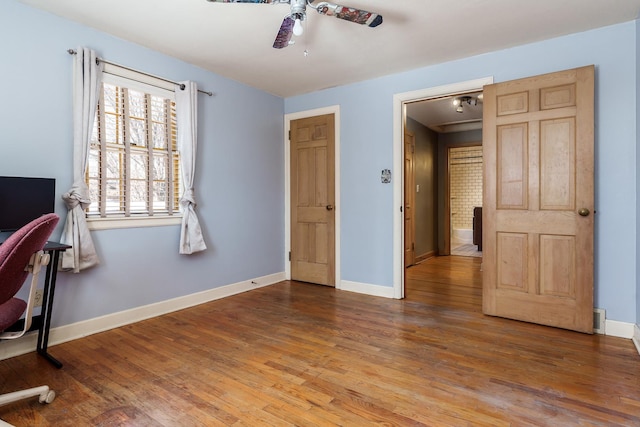 bedroom featuring a ceiling fan, baseboards, and wood finished floors