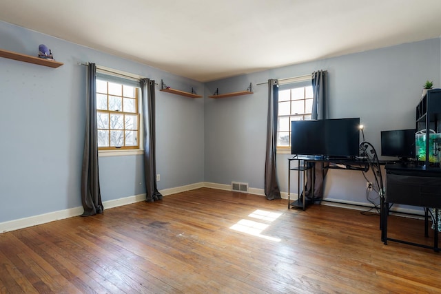 interior space with visible vents, baseboards, and hardwood / wood-style flooring