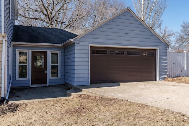 view of front facade featuring roof with shingles and fence