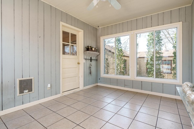 empty room with a wealth of natural light, visible vents, a ceiling fan, and light tile patterned flooring