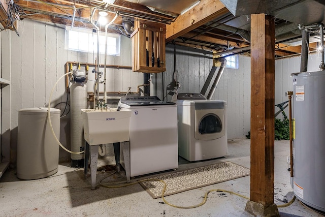 laundry area featuring gas water heater, washing machine and dryer, laundry area, and a sink