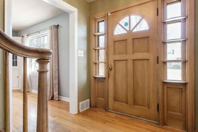 foyer entrance featuring baseboards, visible vents, and light wood finished floors