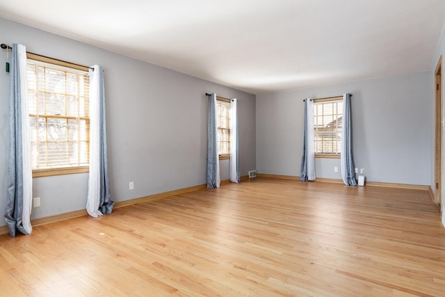 spare room with visible vents, baseboards, and light wood finished floors