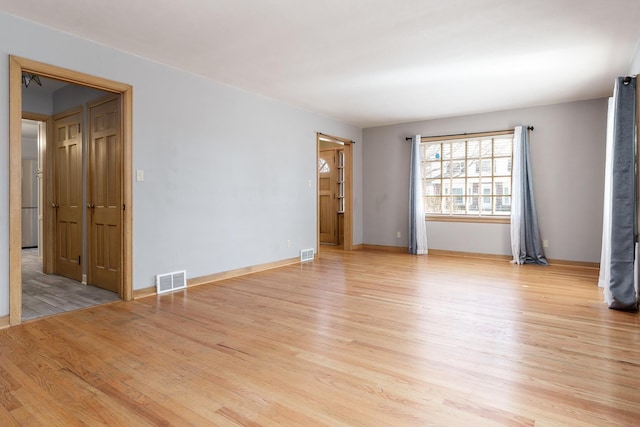 spare room featuring visible vents and light wood-type flooring