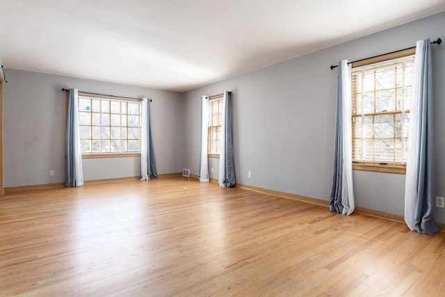 spare room featuring light wood finished floors and baseboards