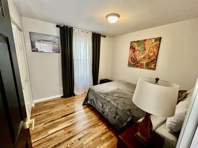 bedroom with baseboards and wood finished floors