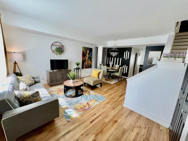 living room with light wood finished floors and a chandelier