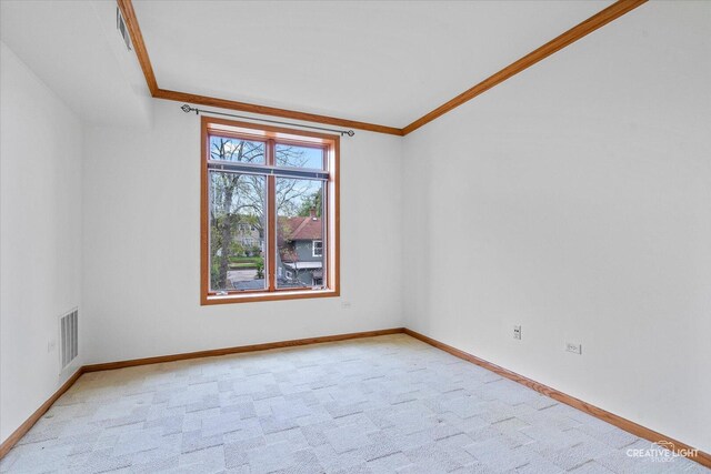 unfurnished room with baseboards, visible vents, ornamental molding, and light carpet