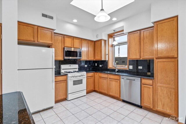 kitchen featuring backsplash, appliances with stainless steel finishes, a sink, and visible vents