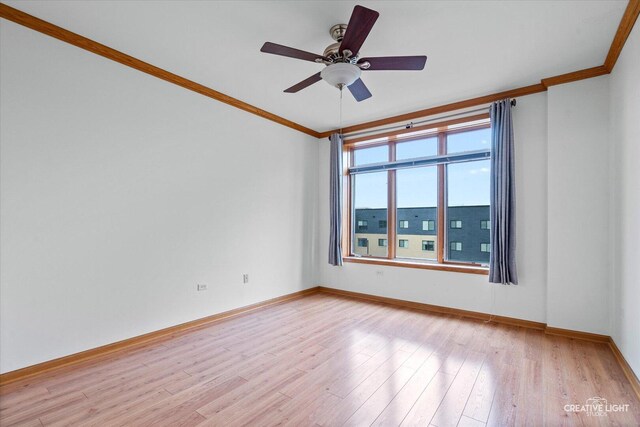 spare room with light wood-style floors, baseboards, ornamental molding, and a ceiling fan