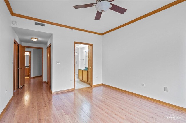 spare room with crown molding, a ceiling fan, visible vents, and light wood-style floors