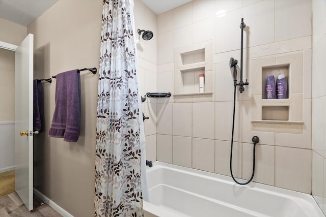 bathroom with baseboards and shower / tub combo with curtain